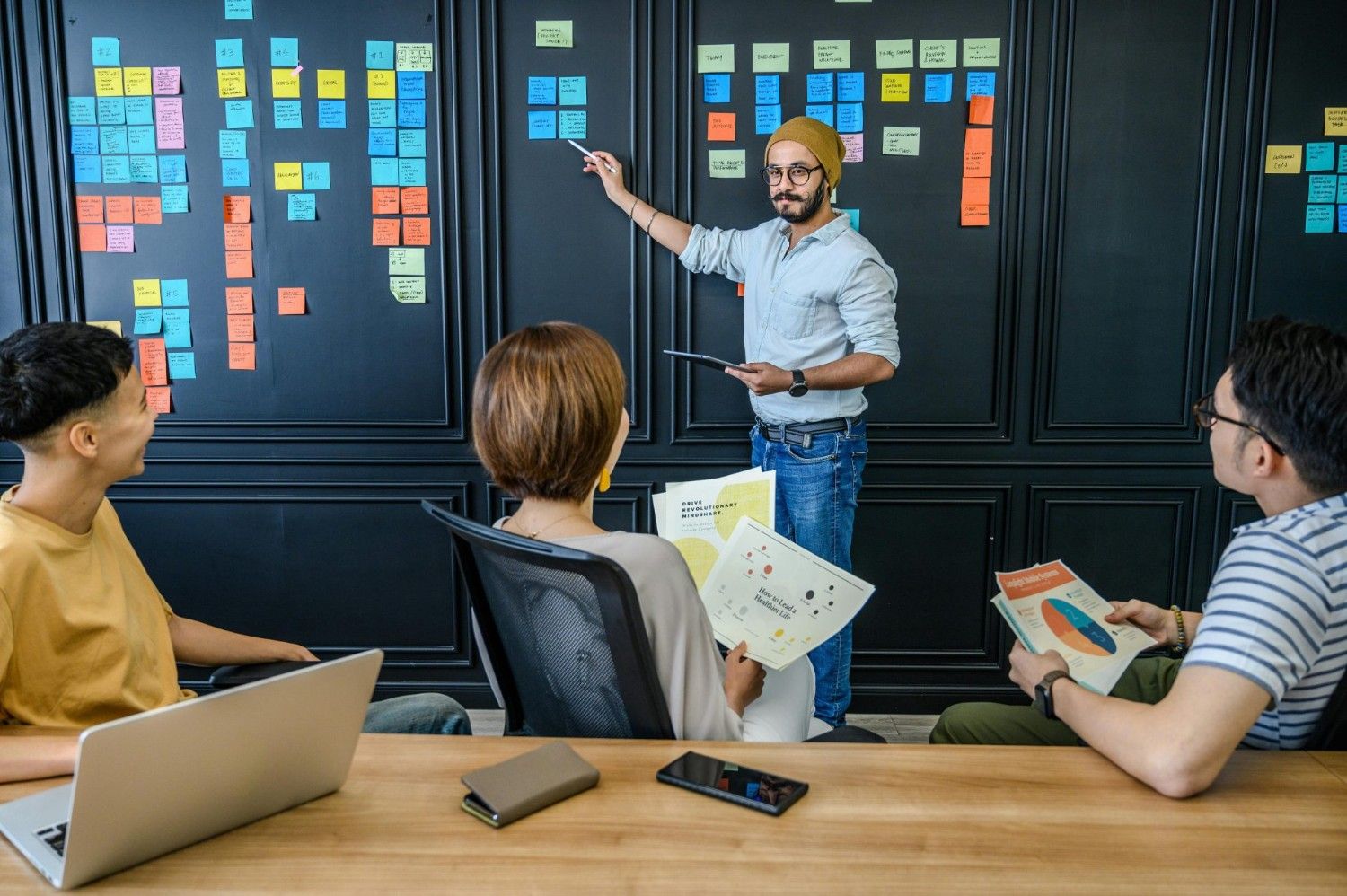 Ein diverses Team beteiligt sich an einer gemeinsamen Brainstorming-Sitzung mit Notizen und Präsentationen.